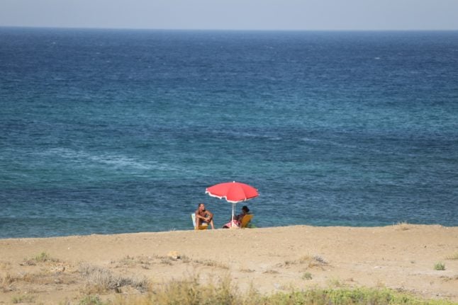 A couple pictured on a free-access beach close to the village of Marzameni, southern Sicily