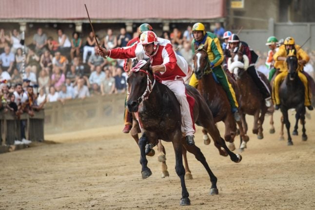 Jockeys ride their horses in the iconic Palio di Siena race