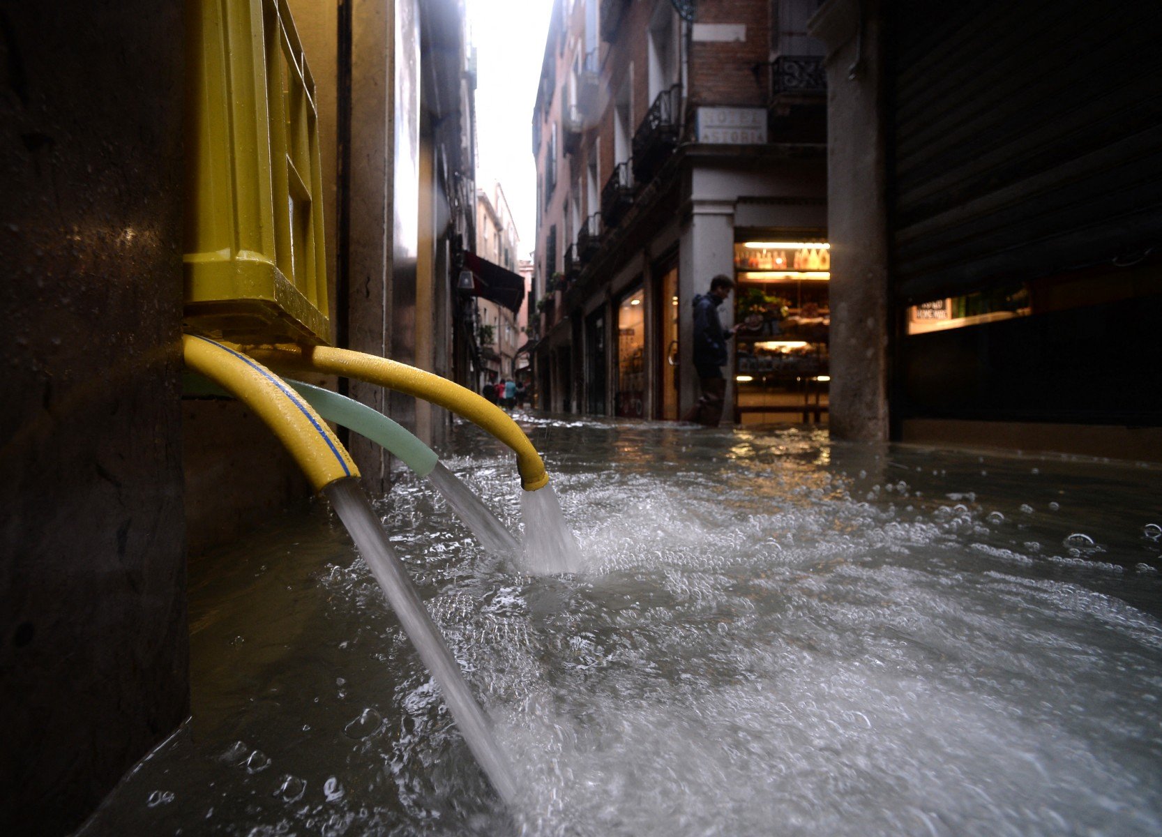 Hoses pump water out of a building in Venice following a severe high tide event.