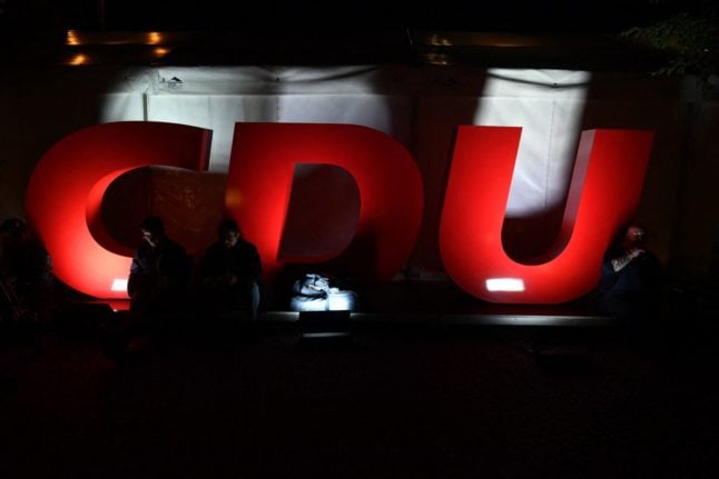 This archive photo shows journalists sitting next to a CDU logo outside the Christian Democratic Union (CDU) headquarters after the 2021 German general elections