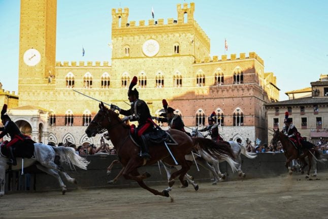 Carabinieri police officers pictured on horseback as they parade through Siena's Piazza del Campo ahead of the popular Palio horse race