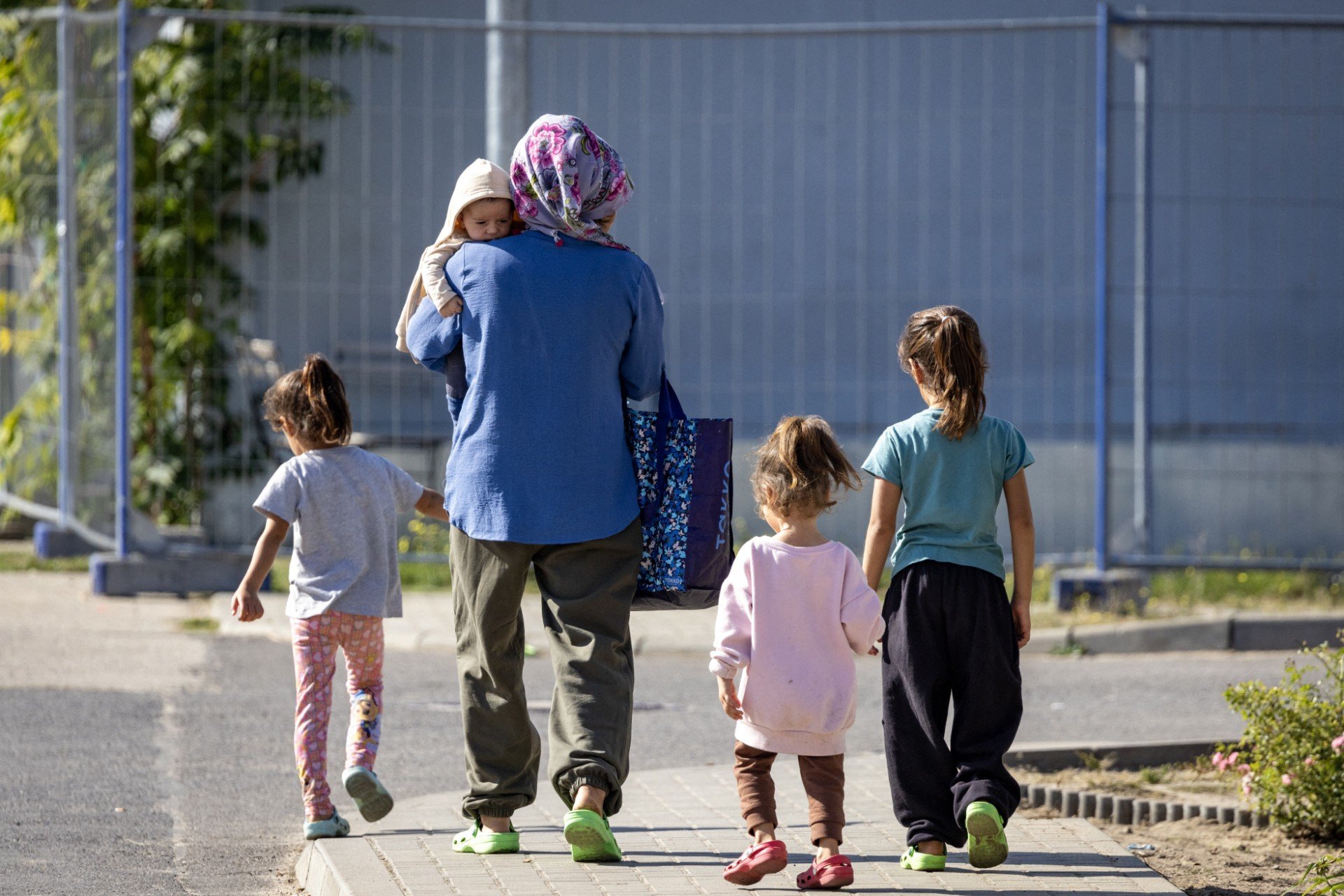 A family walks between housing blocks at Brandenburg's Central Immigration Authority (ZABH) centre, eastern Germany
