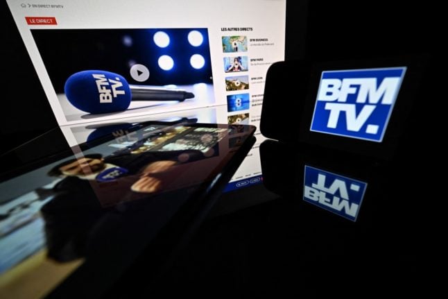 The logo of French television news channel BFM TV displayed on tablet, smartphone and television screens