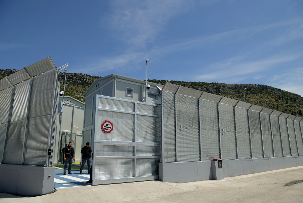 Italian police officers stand guard inside an Italian-run migrant centre near the Albanian port of Shengjin