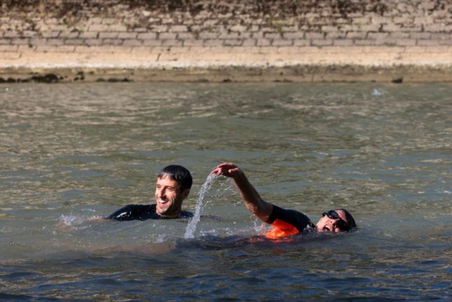 President of the Paris 2024 Olympics and Paralympics Organising Committee (Cojo) Tony Estanguet (L) and Paris Mayor Anne Hidalgo and swim in the Seine, in Paris on July 17, 2024, ahead of the Olympics later this month