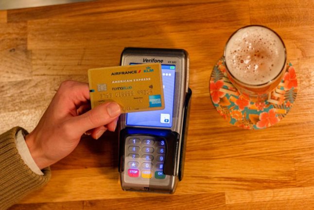Pictured is a person paying for a drink with a card.
