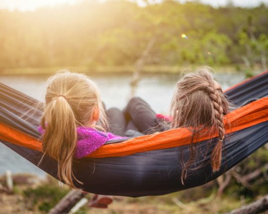 Pictured are two children in a hammock.
