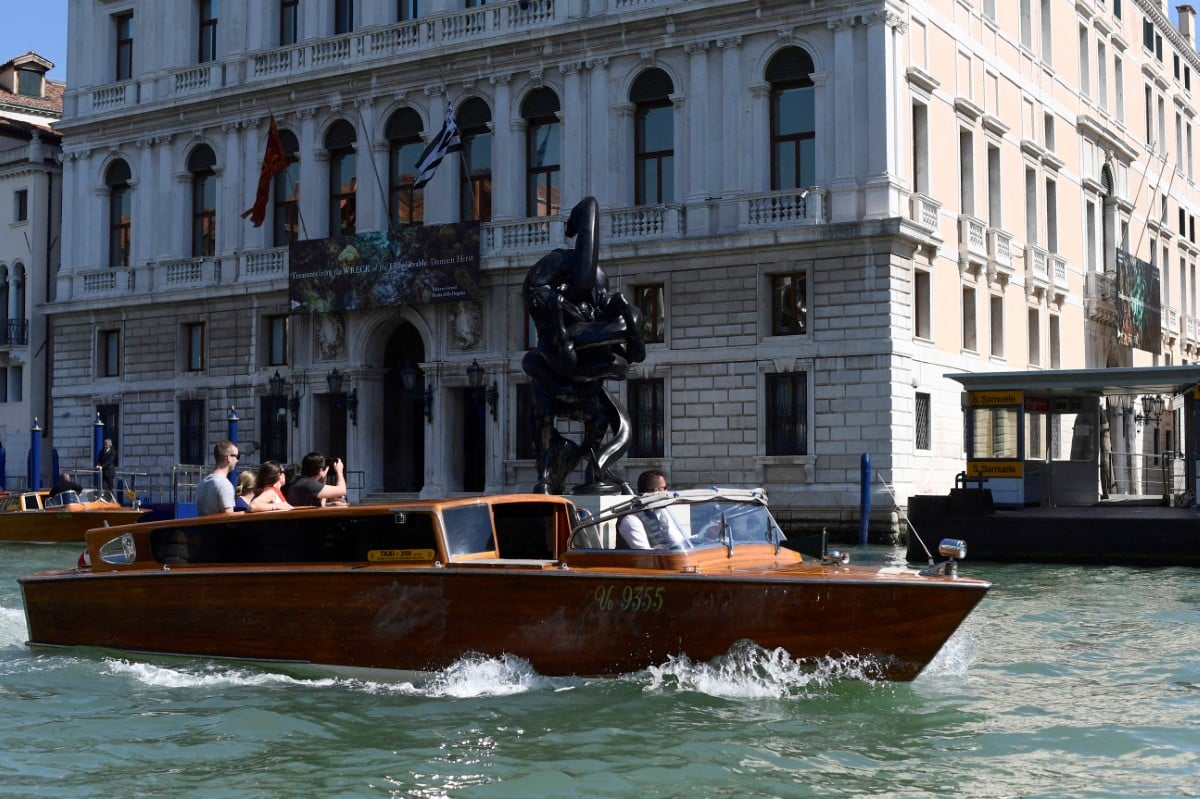 A water taxi passes in front of Venice's Palazzo Grassi museum