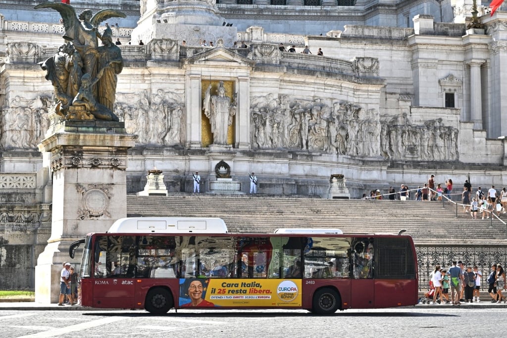 Passengers board a public transport bus in downtown Rome