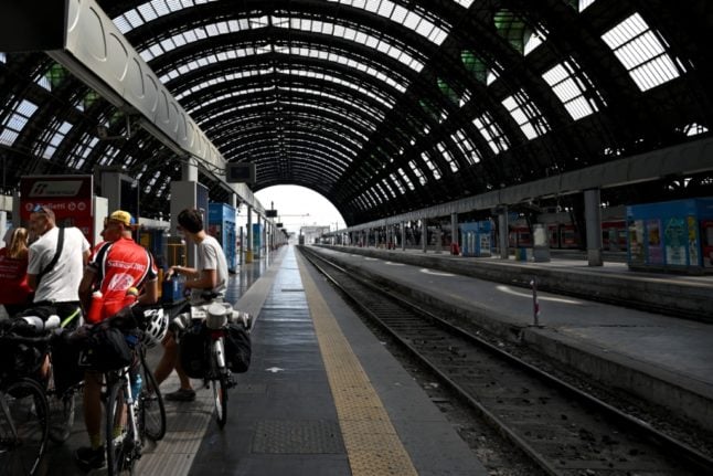Passengers wait for their train on a platform of Milan's Centrale station in July 2023