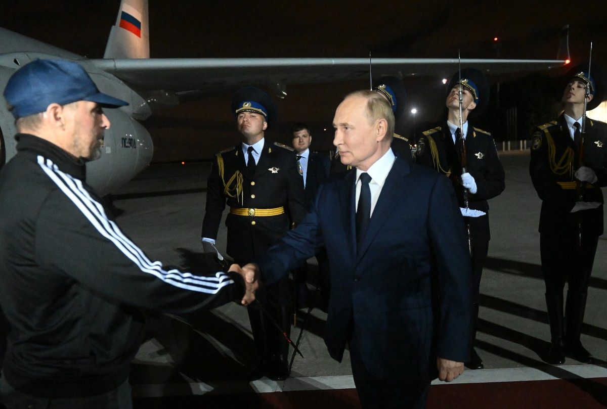 In this pool photograph distributed by Russian state agency Sputnik, Russia's President Vladimir Putin welcomes Vadim Krasikov as Russian citizens released in a major prisoners swap with the West arrive at Moscow's Vnukovo airport on August 1st, 2024. 