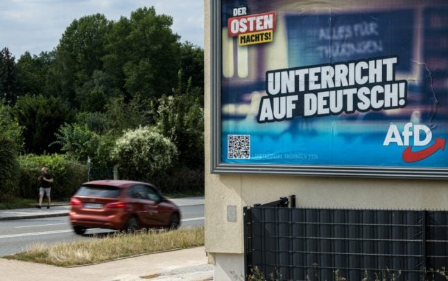 A car drives past a billboard displaying an election campaign poster for Alternative for Germany (AfD) with the lettering 'The east is doing it - class in German' in Altenburg, eastern Germany on August 20th