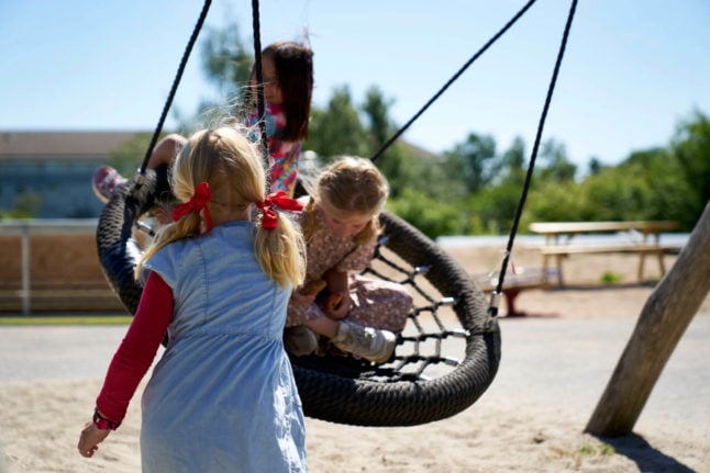 Children playing on a swing