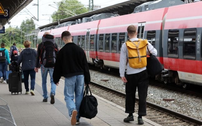 Passengers next to a regional train in Rostock.