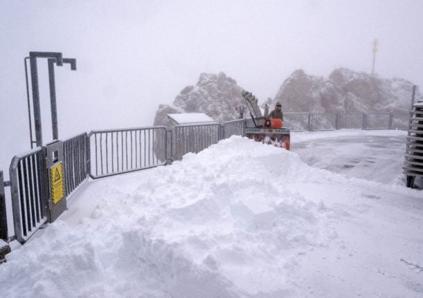 A woman clears the fresh snow from the Zugspitze observation platform in Garmisch-Partenkirchen.