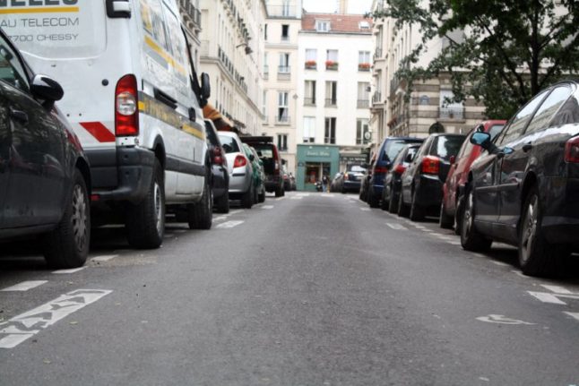 Cars parked along pavements in a street in Paris