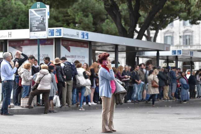 Passengers pictured standing at a bus station during a nationwide transport strike