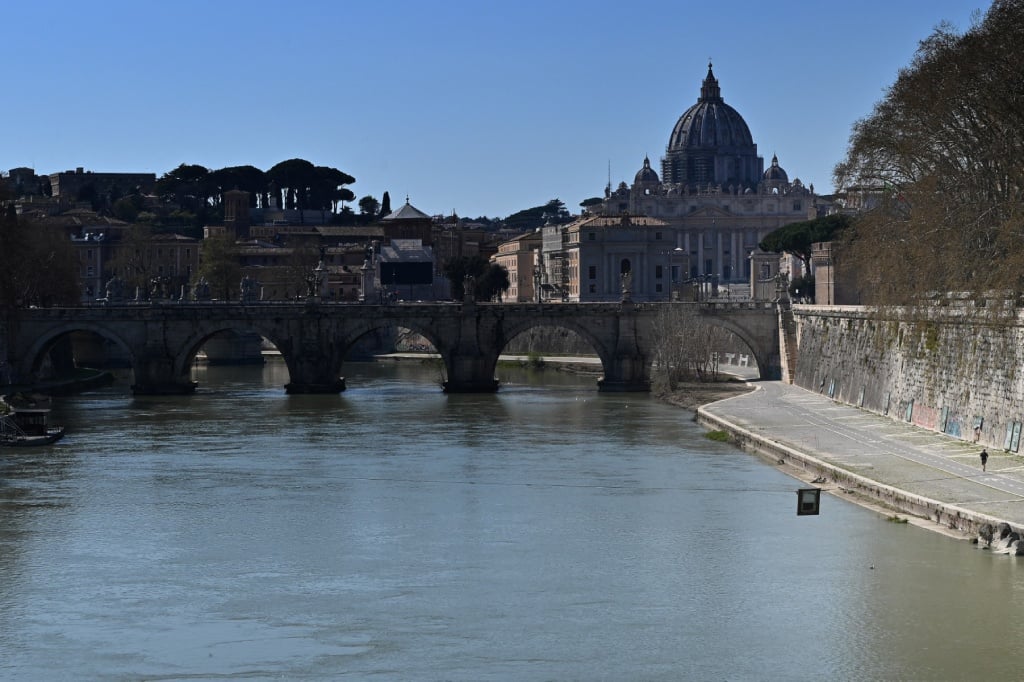 A man jogs along a bank of Rome's Tiber river.