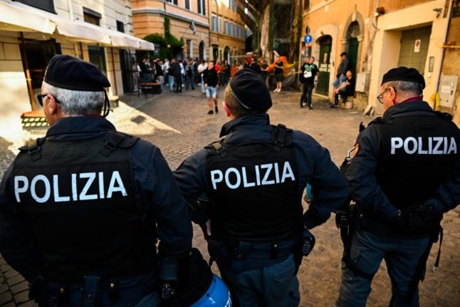 Police officers patrol a street in central Rome