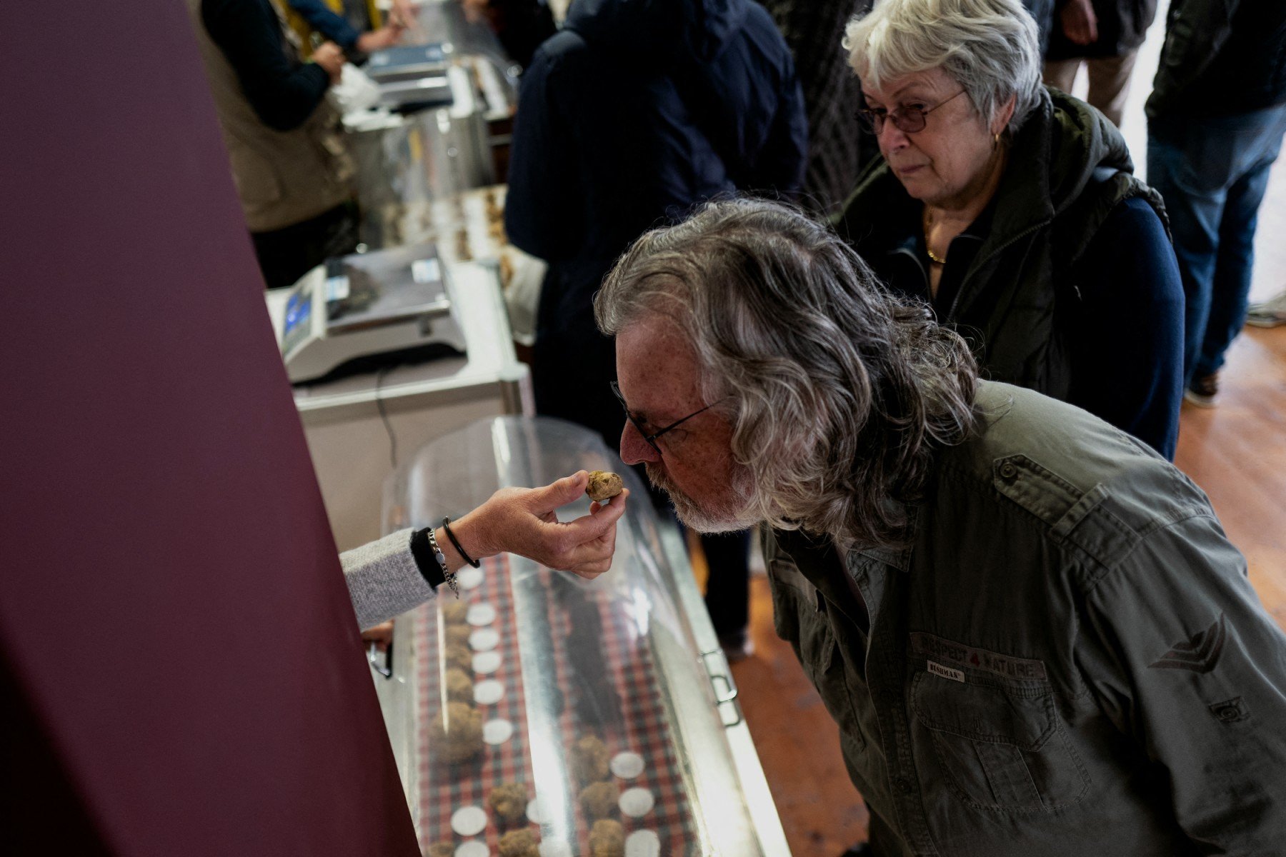 A man smells a white truffle at the truffle fair of Alba, northwestern Italy, in October 2023