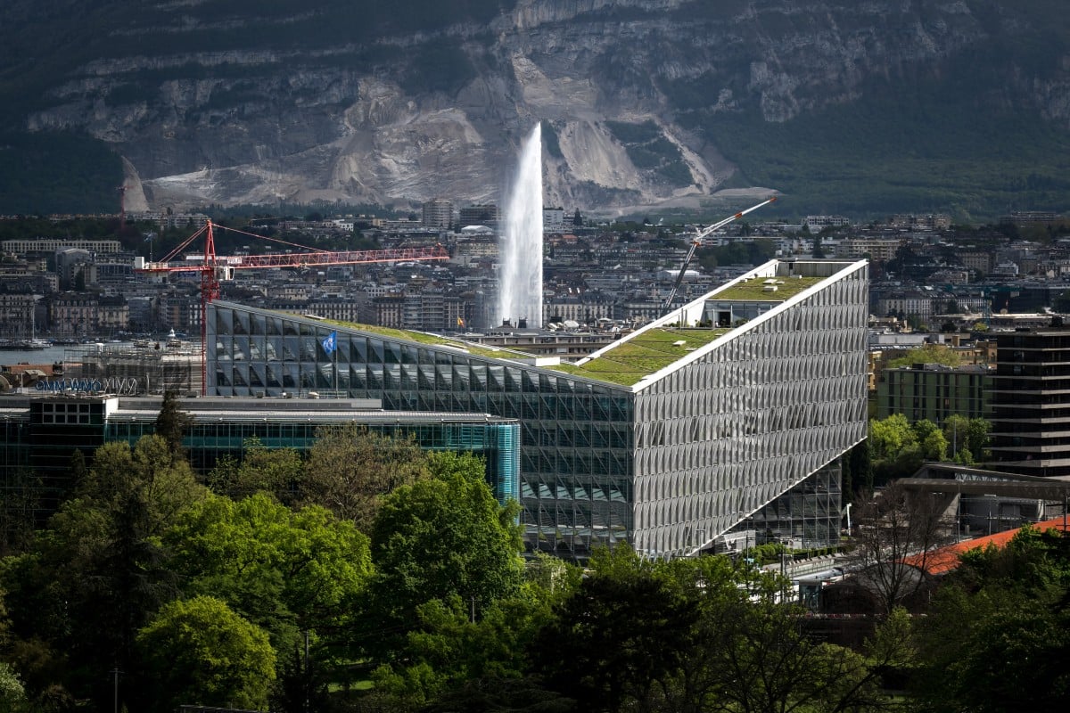 This photo shows Geneva's landmark fountain, known as "Jet d'Eau, downtown Geneva, behind the building (C) hosting the headquarters of Japan Tobacco International (JTI). 