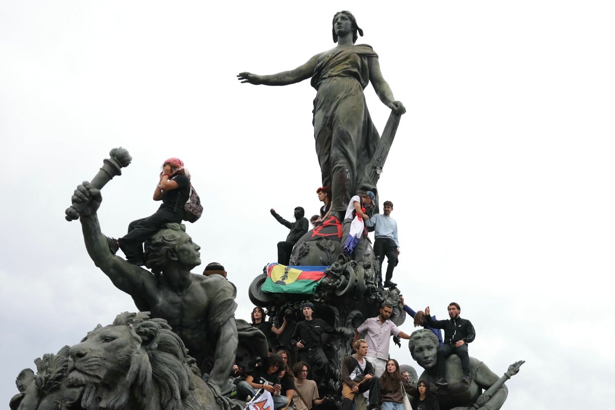 Protesters climbs on the statue 'Le Triomphe de la Republique' at Place de la Nation