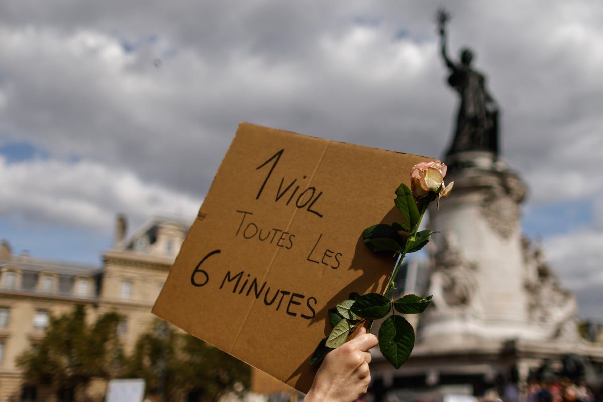 A protester holds a placard reading "1 rape every 6 minutes" during a demonstration in support of Gisele Pelicot on Place de la Republique in Paris 