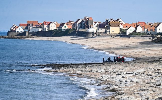 French gendarme use a tractor to pull a damaged migrants' boat after a failed attempt to cross the English Channel that led to the death of 8 people near the beach of Ambleteuse, northern France