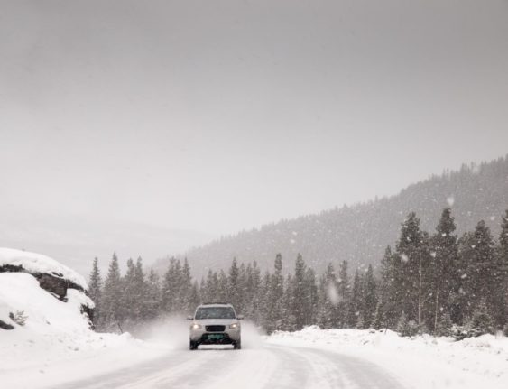 Pictured is a car on a wintery Norwegian road.