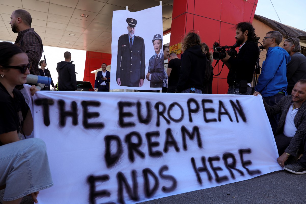 A group of human rights activists gather in protest after the first group of migrants intercepted in Italian waters arrived at the Shengjin port in Albania