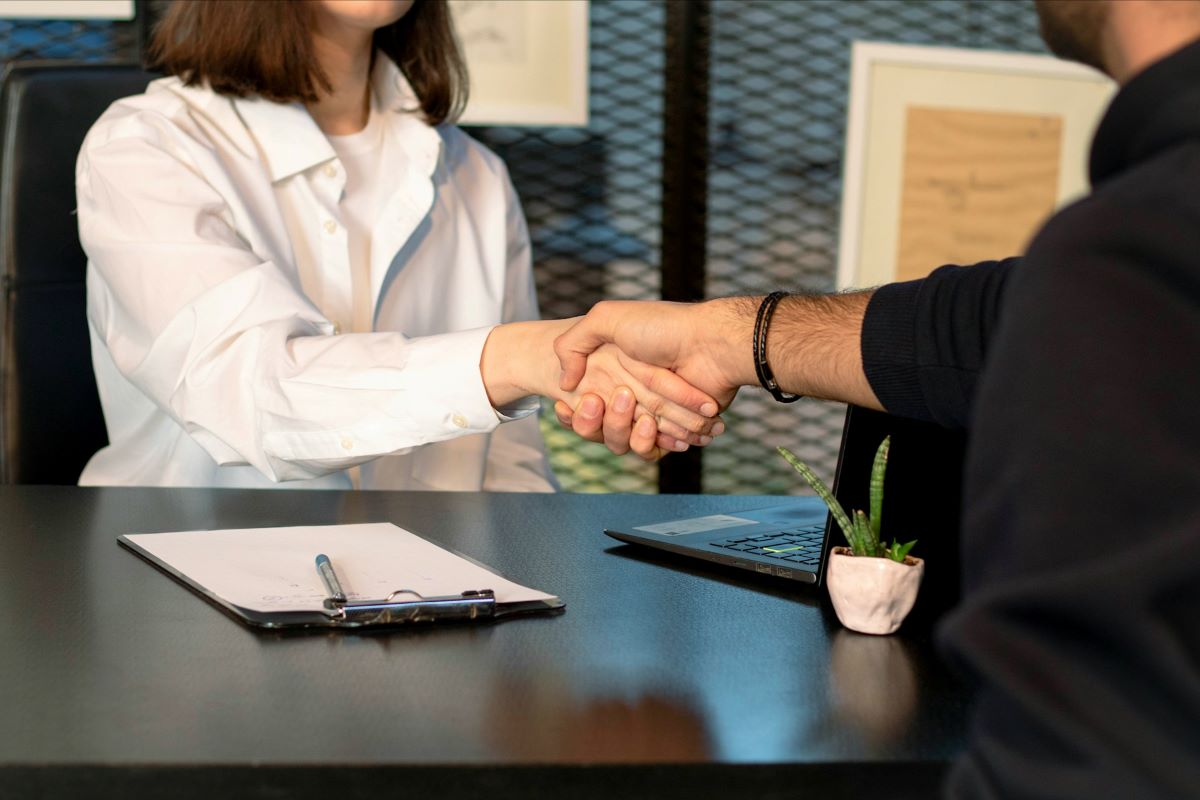 A person shaking hands in a job interview.