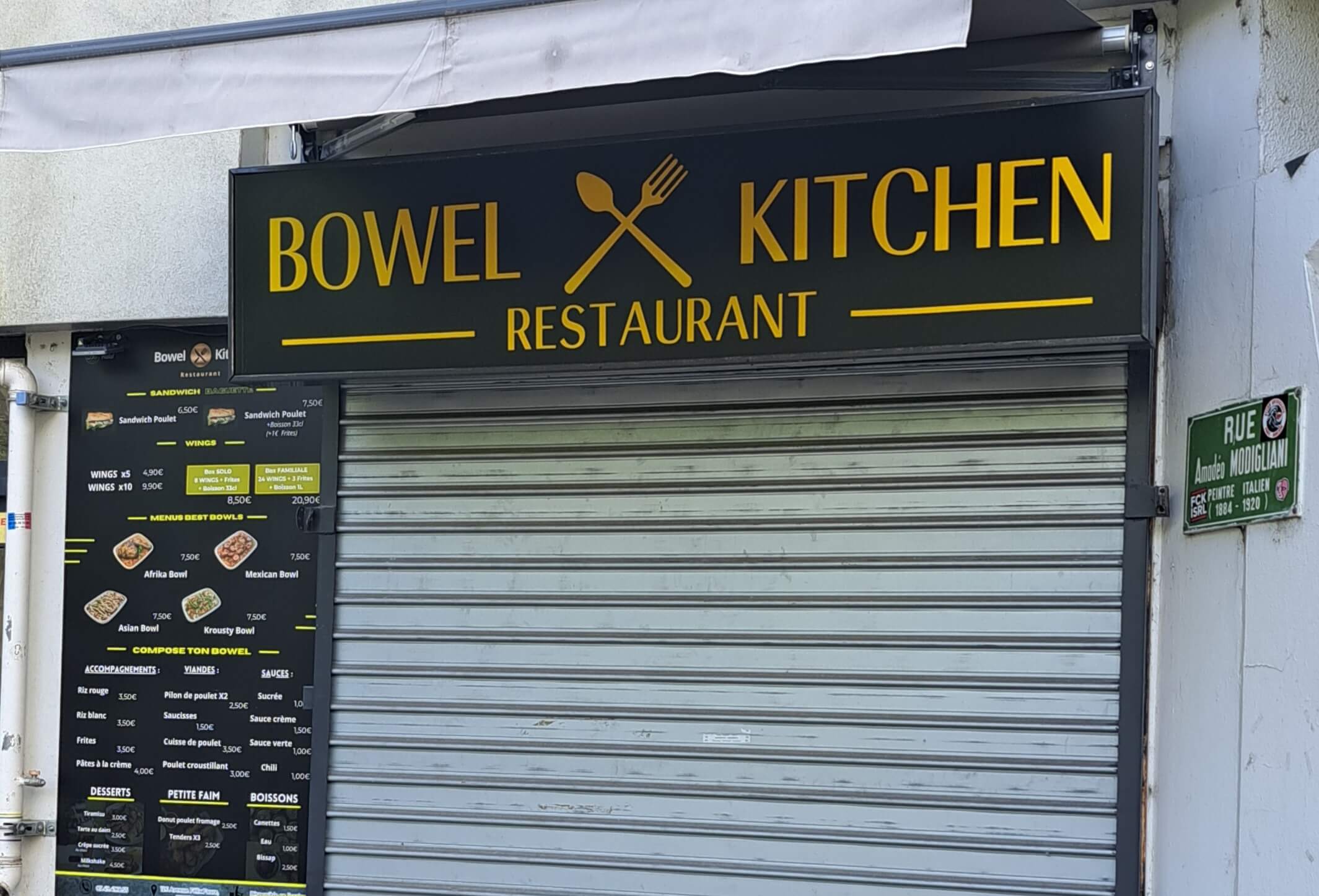 A closed restaurant, with the sign showing its name Bowel Kitchen