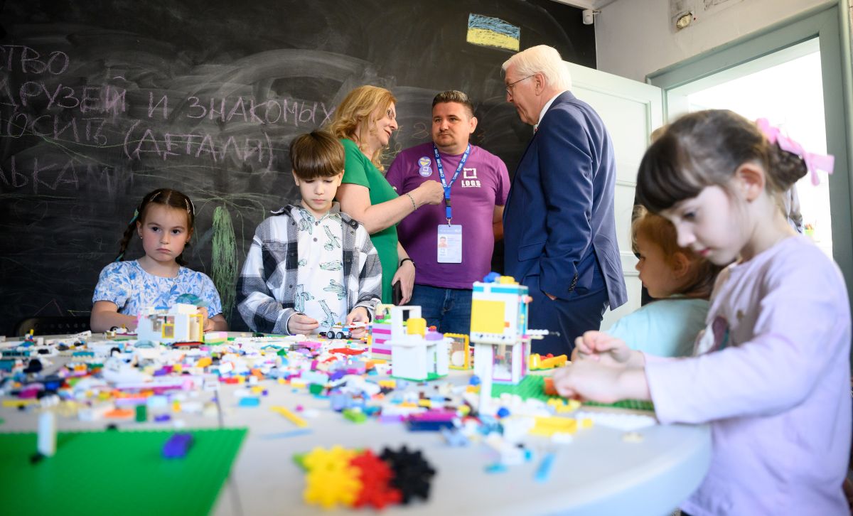 German president is seen in a room full of children playing with toys at a welcome centre for Ukranian refugees.