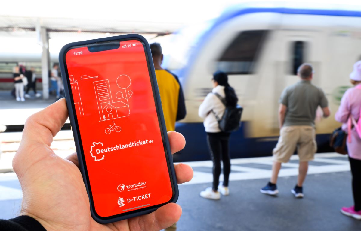 Die App „deutschlandticket.de“ erscheint auf Smartphone-Displays an großen Bahnhöfen.