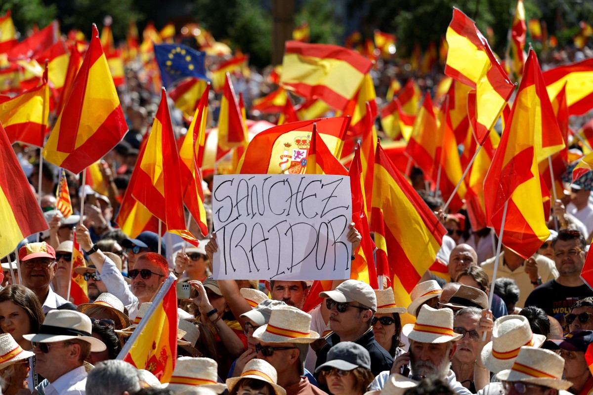 A protester holds a sign reading '(Spain's Prime Minister) Sanchez traitor' during a demonstration called by Spain's right-wing opposition party Partido Popular (PP) to protest against the ruling government in Madrid