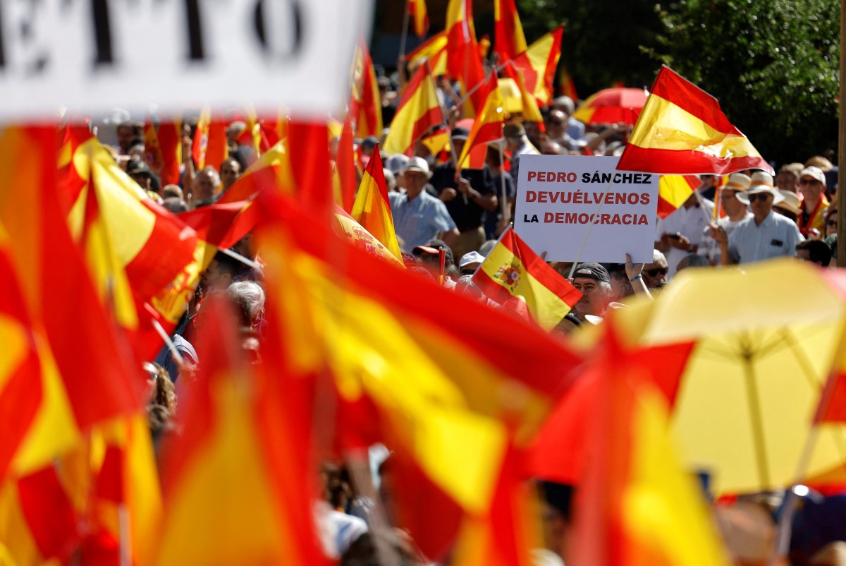 Demonstrators holding a sign reading '(Spain's Prime Minister) Pedro Sanchez, give us back the democracy' attend a demonstration called by Spain's right-wing opposition party Partido Popular (PP) to protest against the ruling government in Plaza de Espana square in Madrid