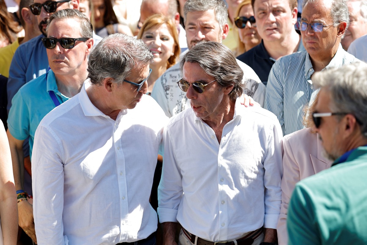 PP's President Alberto Nunez Feijoo (L) talks with Spain's former Prime Minister Jose Maria Aznar during a demonstration called by Spain's right-wing opposition party Partido Popular (PP) to protest against the ruling government in Plaza de Espana square in Madrid 