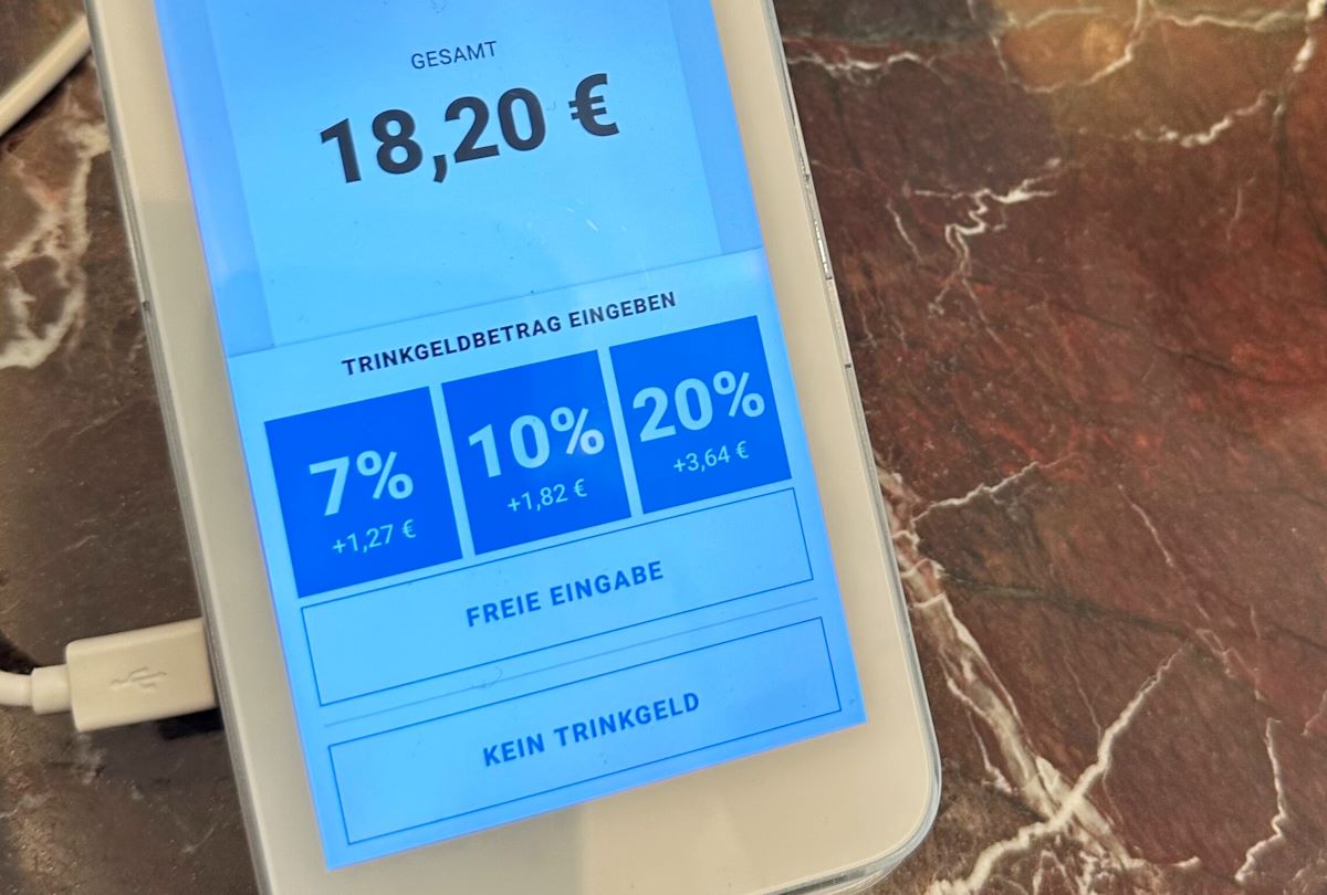 The display of a card reader in a café shows selectable tip options.