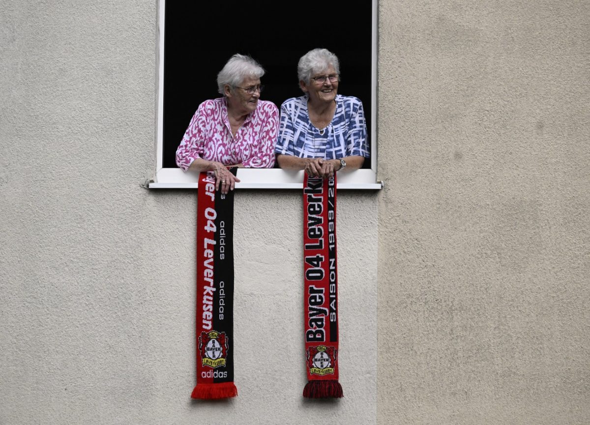 Fans at a window with Leverkusen's scarves as Leverkusen's fans celebrate their team's double victory in the German Bundesliga and the German cup in Leverkusen, western Germany, on May 26, 2024.