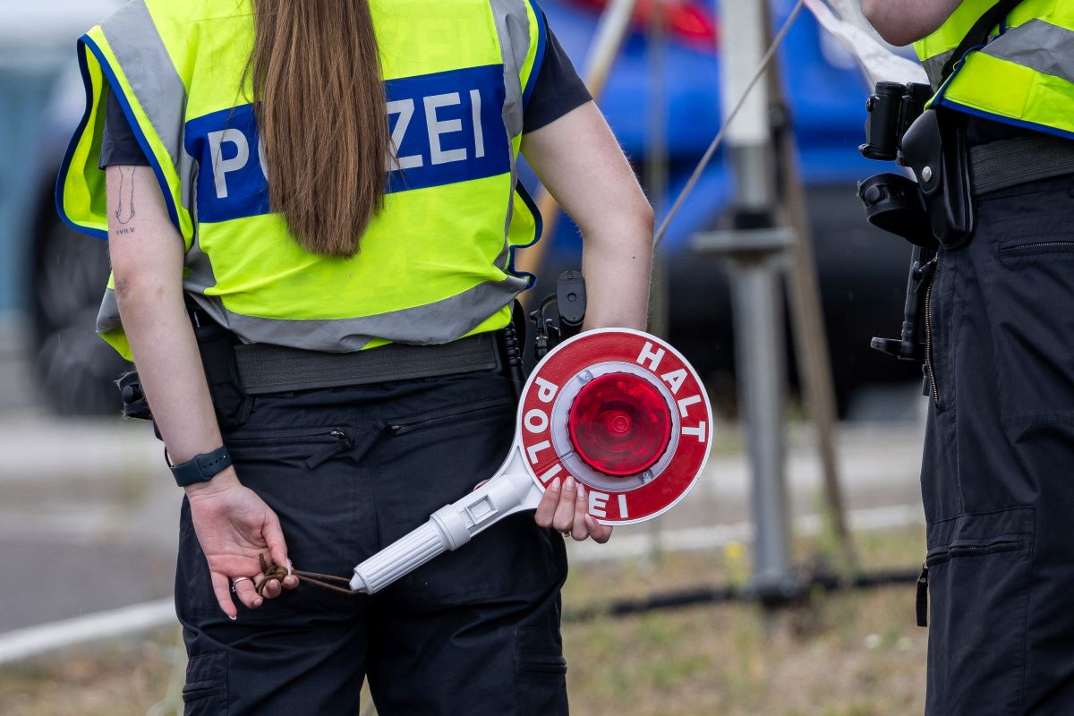 A German police officer holds a signalling disc during controls at the Polish-German border in Frankfurt an der Oder, Brandenburg, eastern Germany, on July 7, 2025
