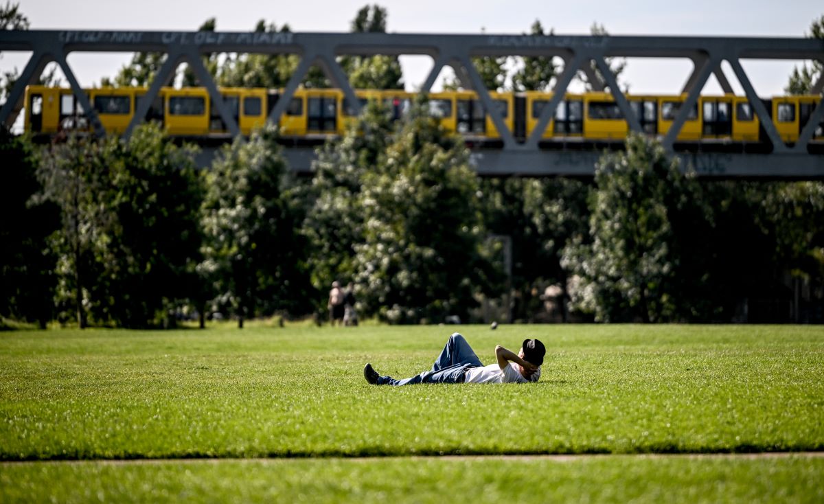 a man lies on a meadow in Gleisdreieck park in Berlin