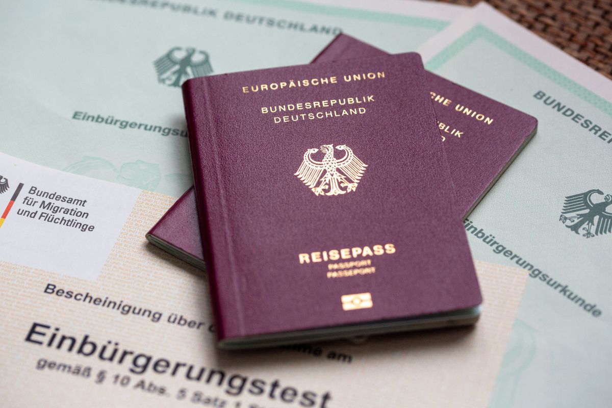 German passports are stacked on a naturalisation test.