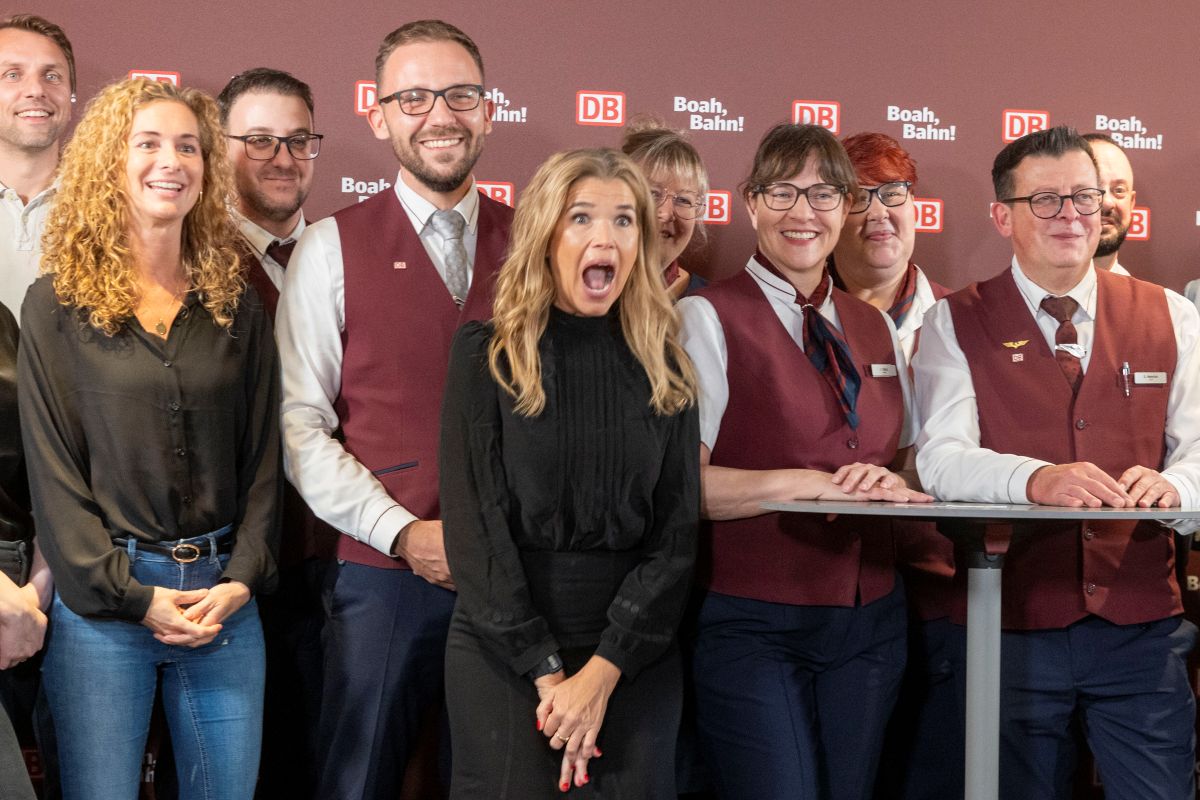 Anke Engelke makes a funny face in front of a group of DB employees.