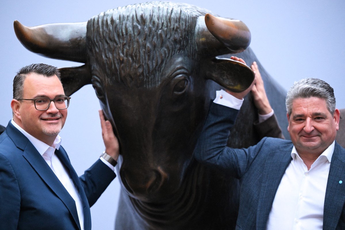 Men in suits put their hands on a metal bull.