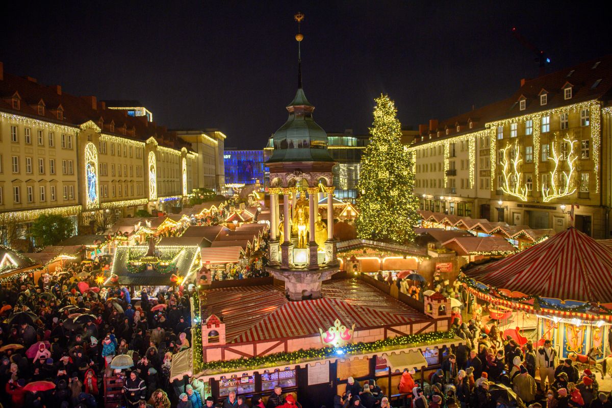 The Magdeburg Christmas market is seen lit up and full of people.