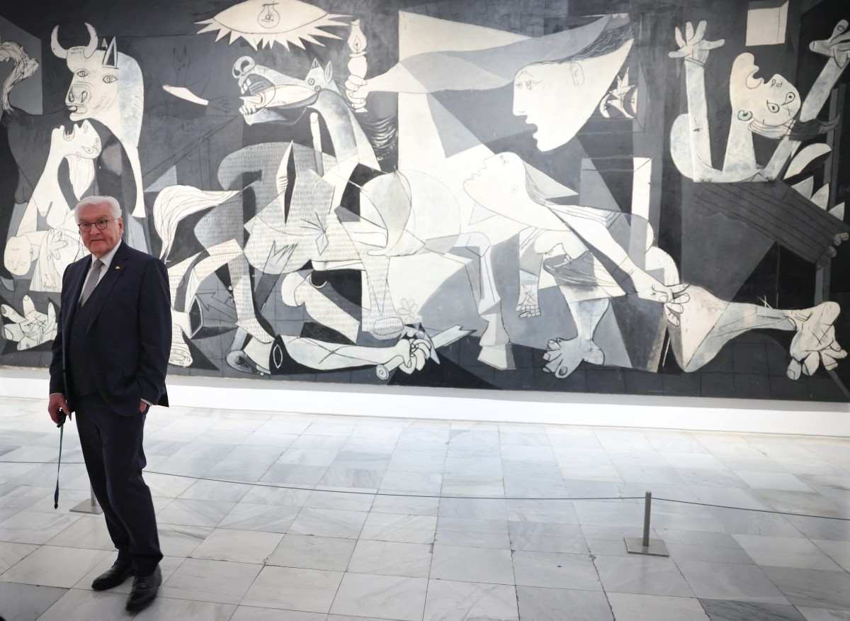German president stands in front of Guernica by Picasso.