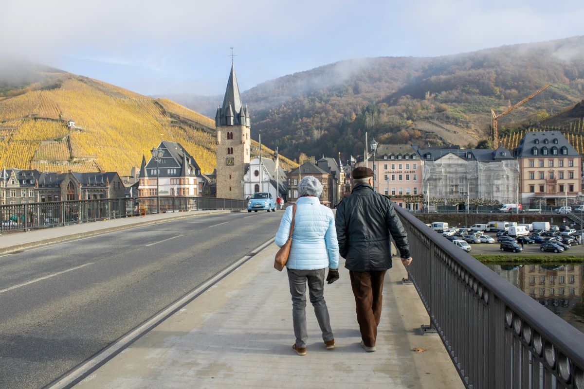 an older couple walk across a bridge in Germany