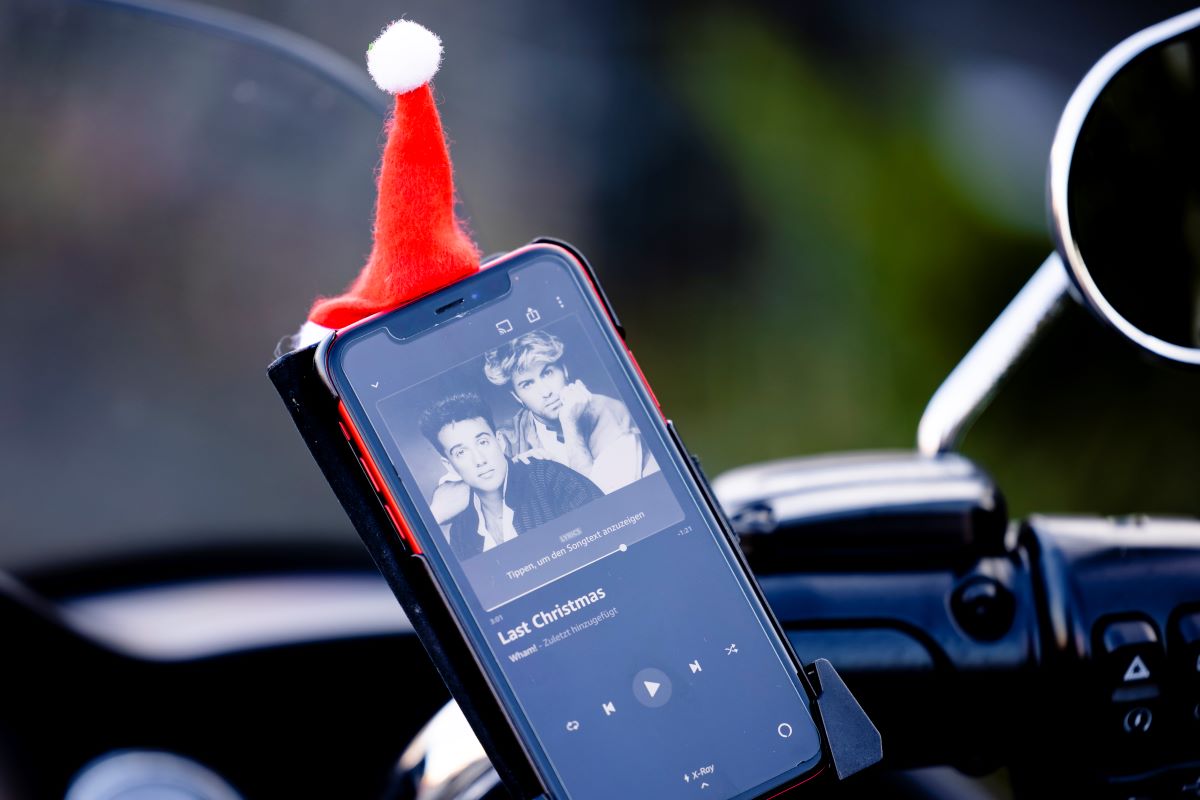The display of a smartphone attached to a motorcycle shows the British group Wham and the words âLast Christmas.â