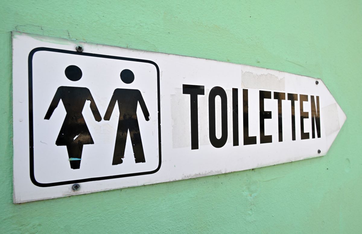 A sign points the way to the nearest public toilet.