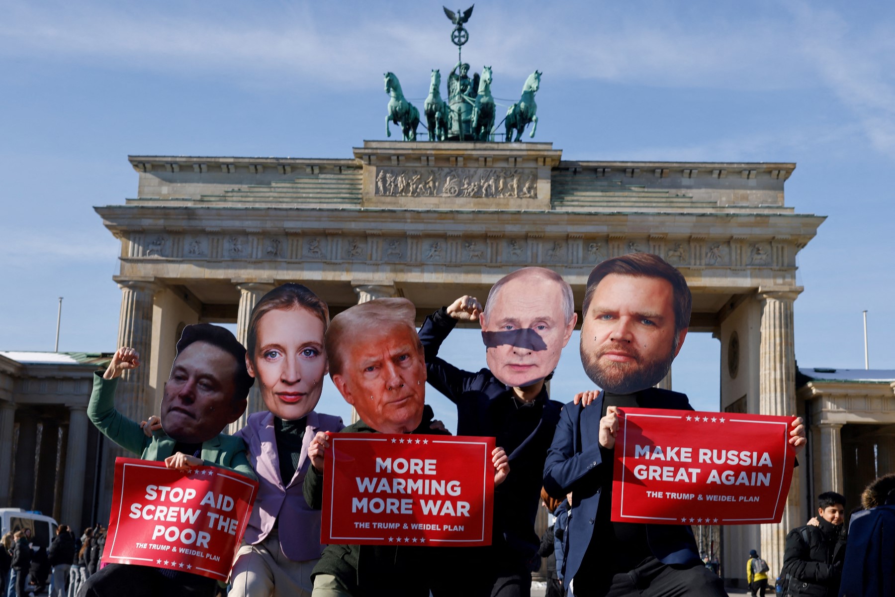 People wear masks of Elon Musk, Alice Weidel, Trump and Putin, holding signs that say 'Make Russia Great again' and 'more warming more war'.